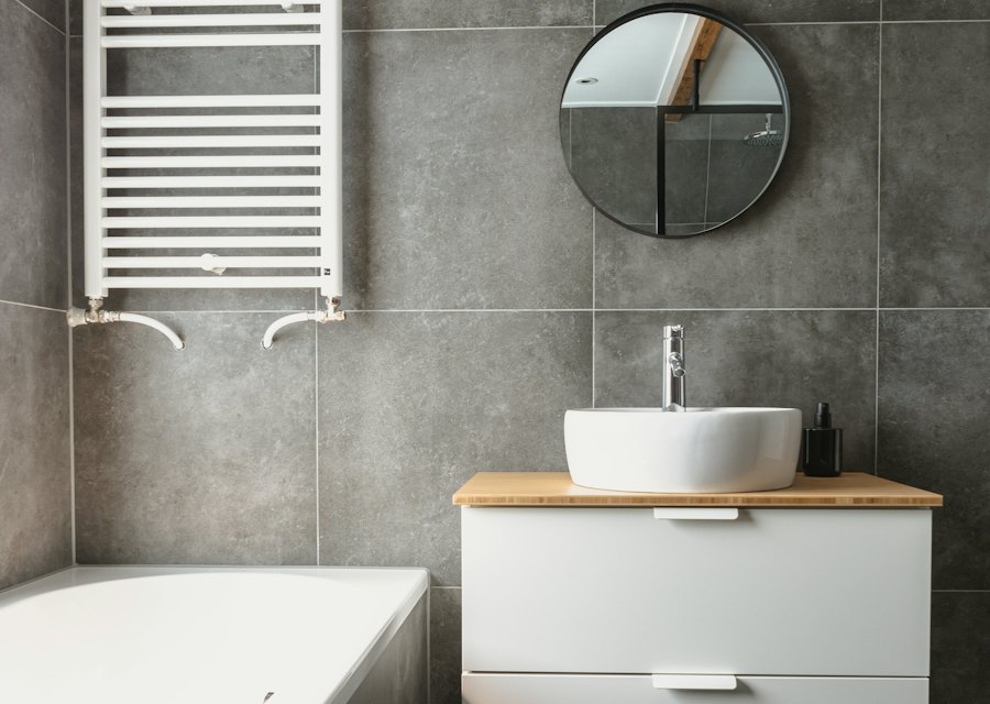 Finished bathroom with a towel radiator and grey tiles