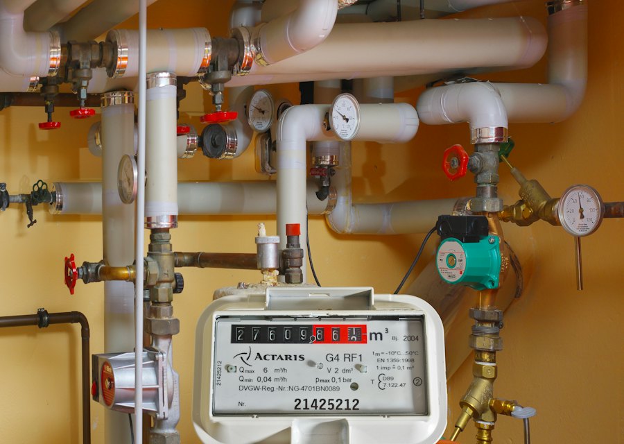Boiler pipework and gas meter in a utility cupboard