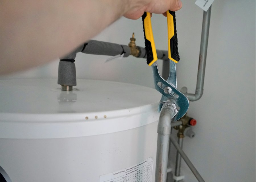 Engineer tightening a fitting on a hot water cylinder